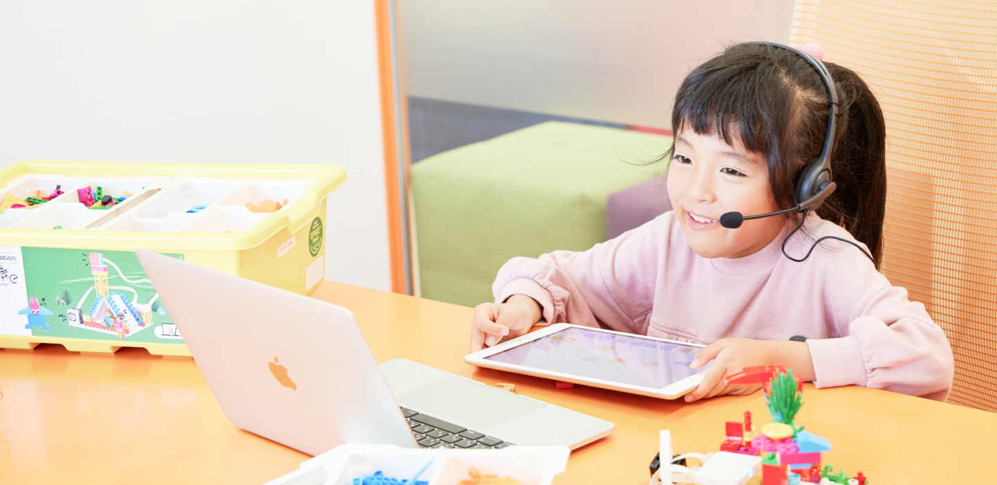 ヘッドセットをつけてオンライン授業を受ける女の子