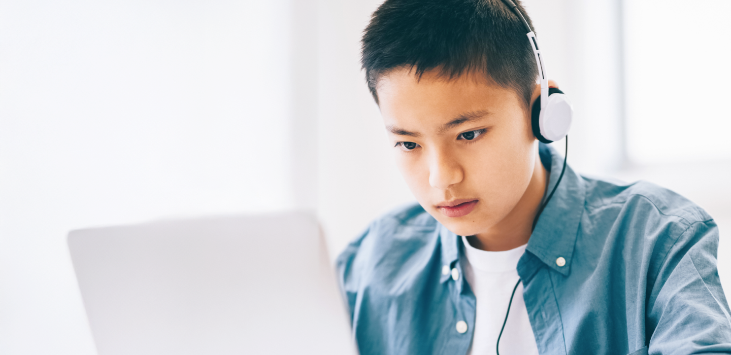 ヘッドホンをつけてノートパソコンで学習する男の子